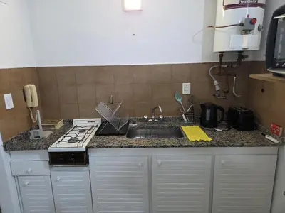 a kitchen counter with a stove and a sink at Monoambiente cómodo zona centro in Cordoba