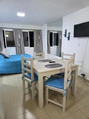 a dining room with a table and chairs and a bed at Monoambiente cómodo zona centro in Cordoba