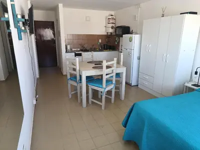 a kitchen with a table and chairs and a refrigerator at Monoambiente cómodo zona centro in Cordoba