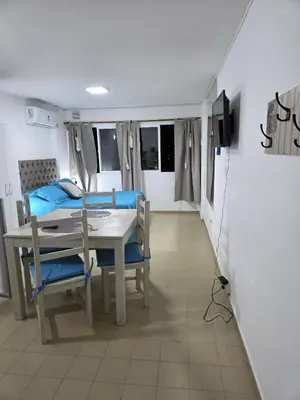 a dining room with a table and chairs and a television at Monoambiente cómodo zona centro in Cordoba