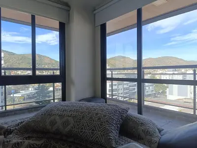 a bedroom with a bed and large windows with mountains at Miralejos 7 in Villa Carlos Paz