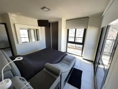 a bedroom with a bed and a couch and windows at Miralejos 7 in Villa Carlos Paz
