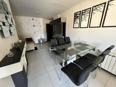a living room with a glass table and black chairs at Miralejos 7 in Villa Carlos Paz