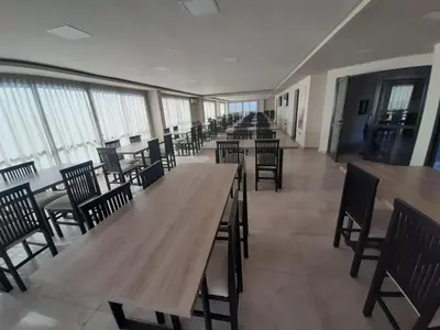 a row of tables and chairs in a room with windows at Miralejos 7 in Villa Carlos Paz