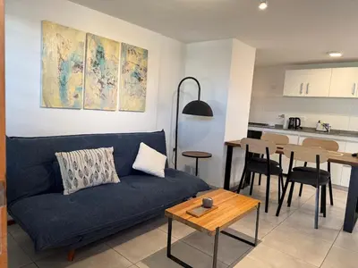 a living room with a blue couch and a table at Stanza Córdoba, Heriberto Martinez, Villa Belgrano in Cordoba