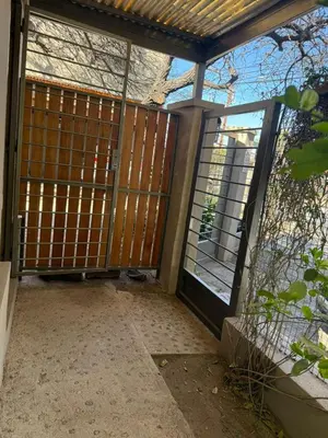 an entrance to a house with a gate and glass doors at Stanza Córdoba, Heriberto Martinez, Villa Belgrano in Cordoba
