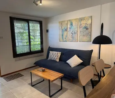 a living room with a blue couch and a table at Stanza Córdoba, Heriberto Martinez, Villa Belgrano in Cordoba