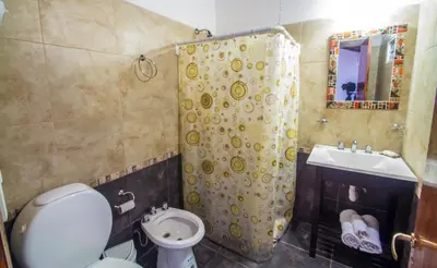 a bathroom with a toilet and a shower and a sink at La Casona Cabañas in Villa Ciudad Parque
