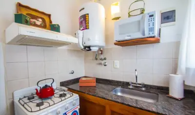 a kitchen with a stove with a tea kettle on it at La Casona Cabañas in Villa Ciudad Parque