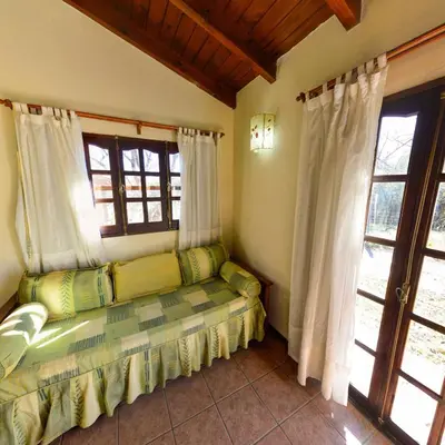 a room with a couch in a room with windows at Pinar del Arroyito in Villa General Belgrano