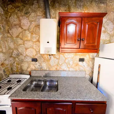 a kitchen with a sink and a stove at Pinar del Arroyito in Villa General Belgrano