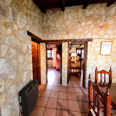 a room with a stone wall and a tile floor at Pinar del Arroyito in Villa General Belgrano