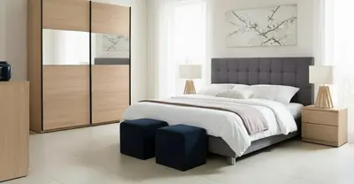 a bedroom with a large bed with a blue foot stool at Depto cómodo en Nueva Córdoba in Cordoba