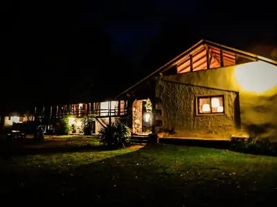 a house lit up at night with a window at Estancia san Miguel in San Miguel de los Rios