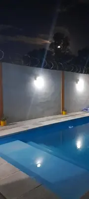 a swimming pool at night with lights above it at hogar entre montañas in Santa María
