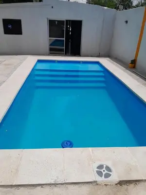 a large blue swimming pool in front of a building at hogar entre montañas in Santa María