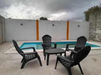 three black chairs and a swimming pool in front at hogar entre montañas in Santa María