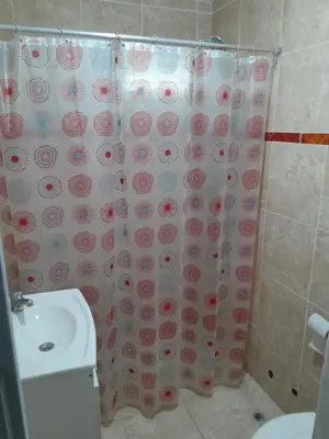 a bathroom with a shower curtain with a toilet at hogar entre montañas in Santa María