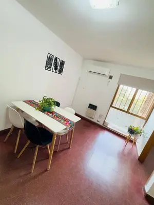 a dining room with a table and chairs in a room at Gral paz Dpto completo con cama queen y seguridad in Cordoba