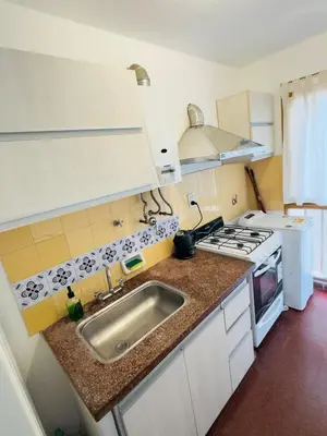 a kitchen with a sink and a stove at Gral paz Dpto completo con cama queen y seguridad in Cordoba