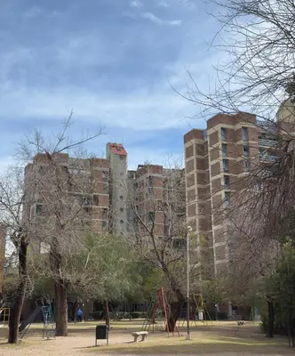 a large brick building with a playground in a park at Gral paz Dpto completo con cama queen y seguridad in Cordoba