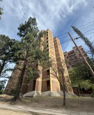 a tall building with trees in front of it at Gral paz Dpto completo con cama queen y seguridad in Cordoba