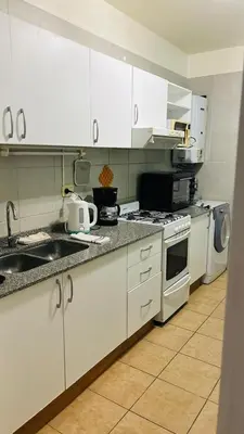 a kitchen with white cabinets and a stove top oven at Excelente Departamento Nueva Córdoba in Cordoba
