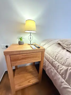 a table with a lamp on it next to a bed at Nueva Córdoba Independencia apart in Cordoba