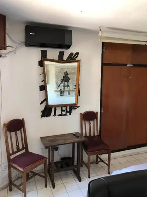 a room with two chairs and a table and a mirror at Departamento céntrico en Córdoba Capital cerca de todo in Cordoba