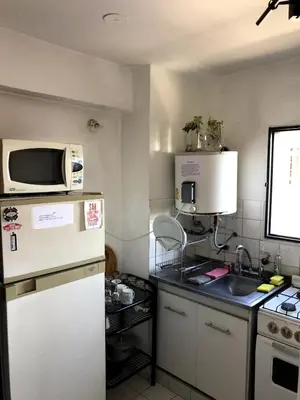 a small kitchen with a microwave and a refrigerator at Departamento céntrico en Córdoba Capital cerca de todo in Cordoba