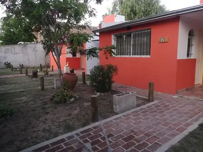 a red and white house with a brick path next to it at Mi casa en tanti casa 26 in Tanti