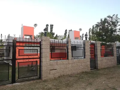 a brick fence with red windows and gates at Mi casa en tanti casa 26 in Tanti