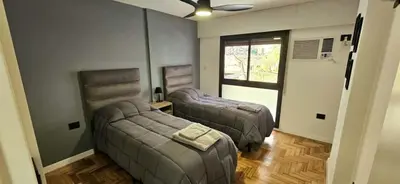 a living room with two beds and a window at Spectacular location close to Buen Pastor in Cordoba