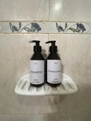 two bottles of shampoo on a shelf in a bathroom at EfeCalm Entre Ríos in Cordoba