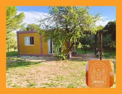 a small yellow house with a sign in front of it at Complejo Genesis MALLIN in Cueva de los Pajaritos