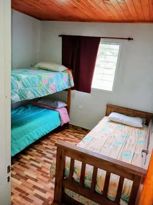 a bedroom with two bunk beds and a window at Complejo Genesis MALLIN in Cueva de los Pajaritos