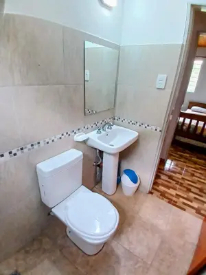a bathroom with a toilet and a sink at Complejo Genesis MALLIN in Cueva de los Pajaritos