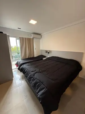 a large black bed in a room with a window at MonoambienteXdia in Villa Dolores