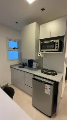 a small kitchen with a stove and a microwave at MonoambienteXdia in Villa Dolores