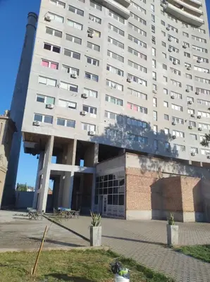 a large white building in front of a building at Comodo y luminoso in Cordoba
