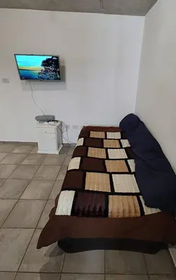 a bed in a room with a tv on a wall at Calixto C in Cordoba