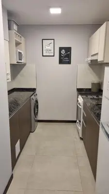 a large kitchen with a washer and dryer in it at BERENICE IV excelente ubicación in Villa Carlos Paz