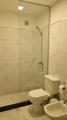 a bathroom with a toilet and a glass shower at BERENICE IV excelente ubicación in Villa Carlos Paz