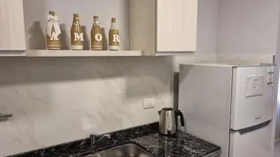 a kitchen with bottles on a shelf above a sink at BERENICE IV excelente ubicación in Villa Carlos Paz