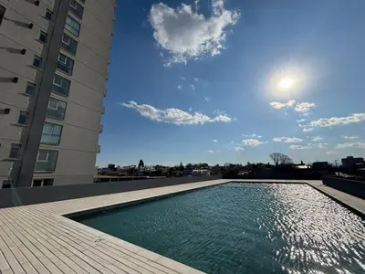 a swimming pool in front of a tall building at Cuidad Gama Luxury - 2 Dormitorios in Cordoba