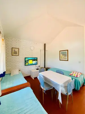 a living room with a white table and blue chairs at Casa con Piscina y Vista al Lago in Villa Santa Cruz del Lago