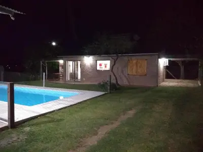 a house with a swimming pool at night at Cabañas Quimera in Santa Rosa de Calamuchita