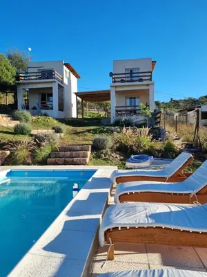 a villa with a swimming pool and a house at Ventura 1 in Villa Carlos Paz