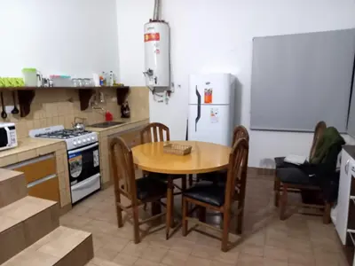 a kitchen with a table and chairs and a refrigerator at La Morada de sus Sueños II in San Roque