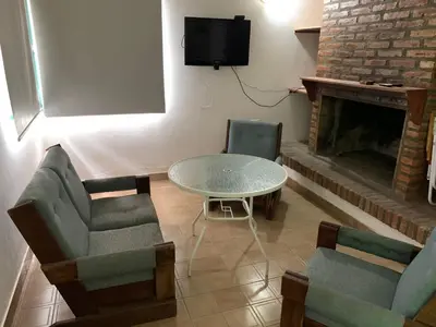 a living room with a table and chairs and a fireplace at La Morada de sus Sueños II in San Roque